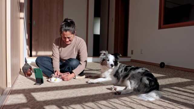 Woman sharing food with her cute dog at home
