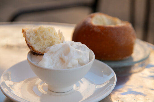Brioche Siciliana with sugar sprinkled on top with mandarola granita., a sweet Italian pastry.