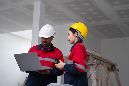 Construction engineers coordinating project tasks with a laptop and two-way radio in building site, highlighting teamwork, site communication, workplace safety, quality control, engineering management