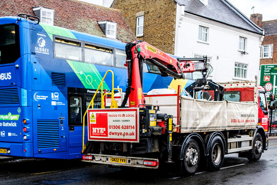 Close Up Of A NYEs Building Supplies Lorry With HIAB Mounted Crane Driving On A Town Centre High Street