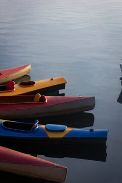 Colorful Kayaks and Boats Resting on Calm Water