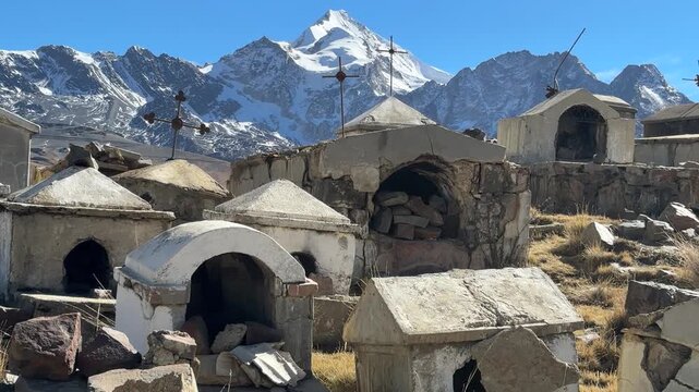 Cemit&eacute;rio hist&oacute;rico de Milluni com o pico nevado Huayna Potos&iacute; ao fundo, Bol&iacute;via. V&iacute;deo vertical de tumbas r&uacute;sticas e cruzes no altiplano andino sob c&eacute;u azul.