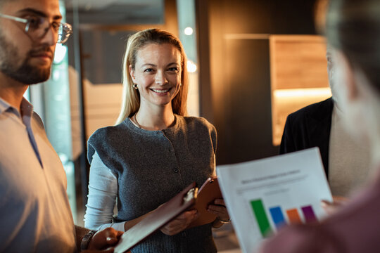 Smiling businesswoman leading team discussion in modern office
