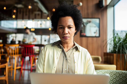 Focused woman working on laptop in a cafe