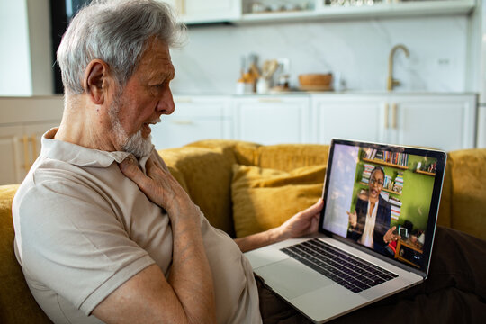 Senior man consulting doctor via video call at home