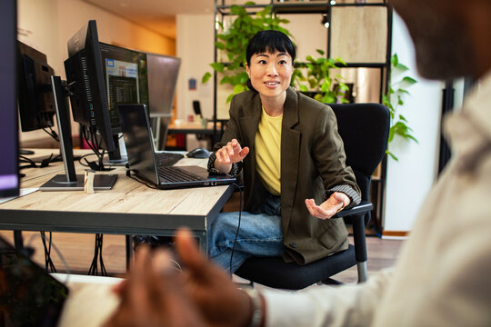 Smiling businesswoman leading discussion in modern office