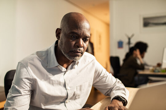 Serious businessman working on laptop in office