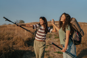 Friends high fiving celebrating hiking success outdoors