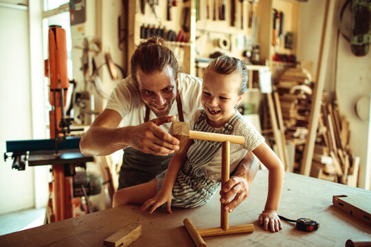 Father and daughter woodworking in home workshop