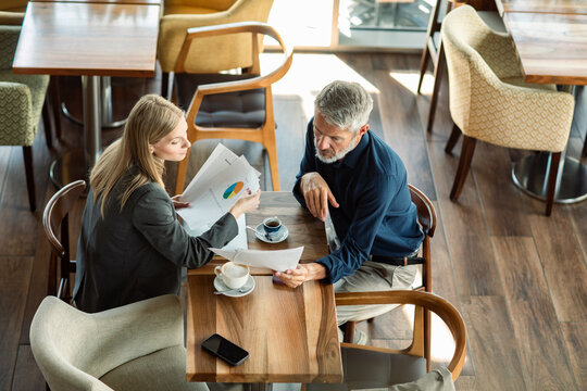 Two business colleagues reviewing charts at cafe