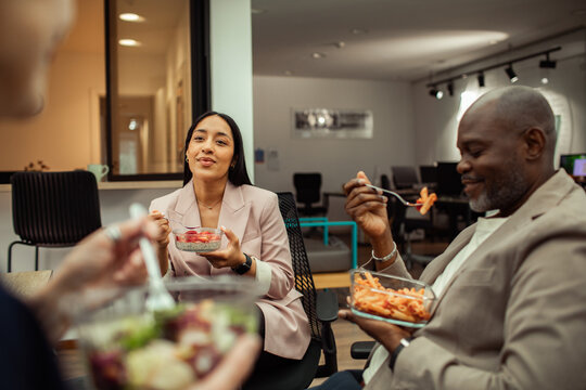 Coworkers sharing lunch break in modern office