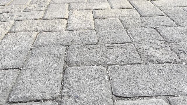 Texturized rectangular concrete pavers surface with natural daylight