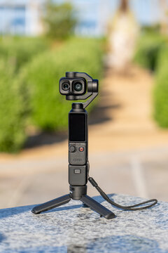 Compact handheld 4K gimbal camera DJI Osmo Pocket 4p with integrated touch screen display mounted on small portable tripod for professional travel vlogging and cinematic outdoor videography production