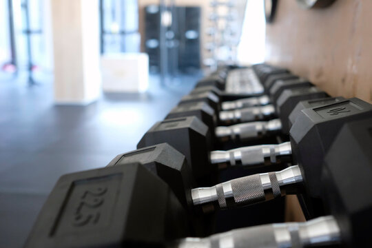Rack with different barbell weights inside a gym