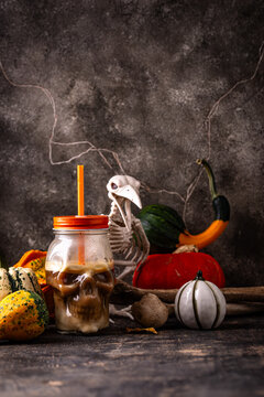 Halloween autumn drink pumpkin spicy latte in glass in shape of skull