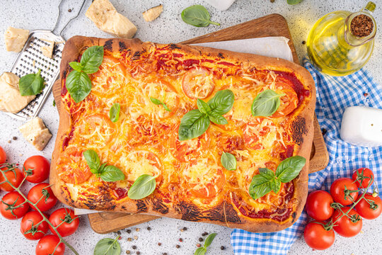 Rectangular homemade pizza with tomatoes and basil