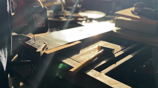 Skilled artisan performing precision work, drilling a hole in a metal sheet with a cordless tool in a sunlit manufacturing workshop