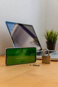 Vertical smartphone with secure access screen and padlock near laptop