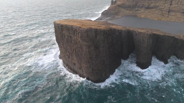 フェロー諸島ヴォーアル島、断崖トレラニパと海に浮かぶように見えるソルバーグスバトン湖の空撮（Faroe Islands Tr&aelig;lan&iacute;pa Cliff Aerial 4K）