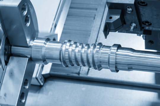 Lead ball screw parts production process on CNC lathe machine in blue tone lighting