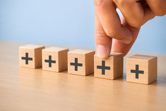 Positive things; added value, benefits, additional, personal development, growth mindset, positive thinking, opportunities, emerging market. Putting the cubes with plus sign to offer positive things.