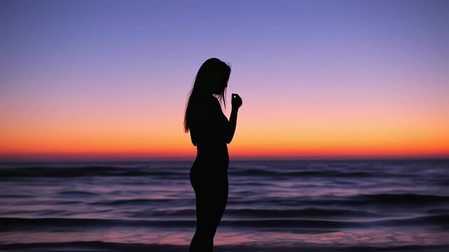 Woman Standing on Beach at Sunset.