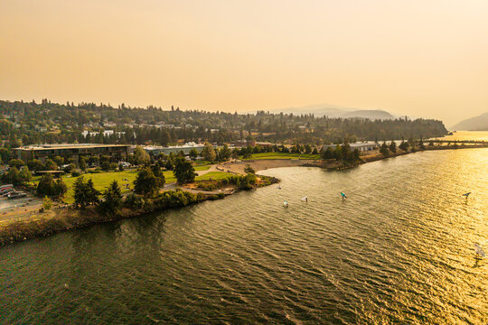 Aerial view of windsurfers on the Columbia River near the waterfront park under a hazy sky filled with wildfire smoke in Hood River, Oregon, United States.