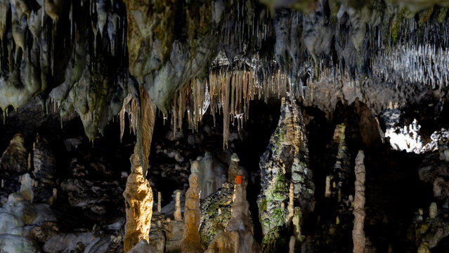 Stalactites and stalagmites inside a dark limestone cave