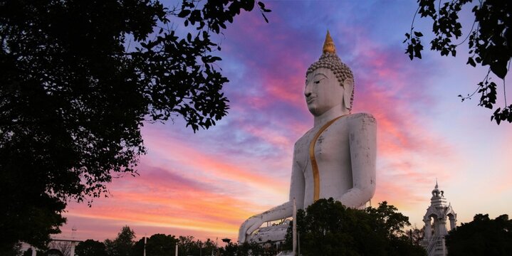Big white Buddha statue with beautiful sunrise sky