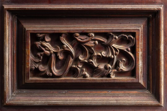 Ornate antique carved wood panel featuring intricate floral scrollwork in framed bas-relief, showcasing rich patina, detailed craftsmanship and vintage decorative style for interior design
