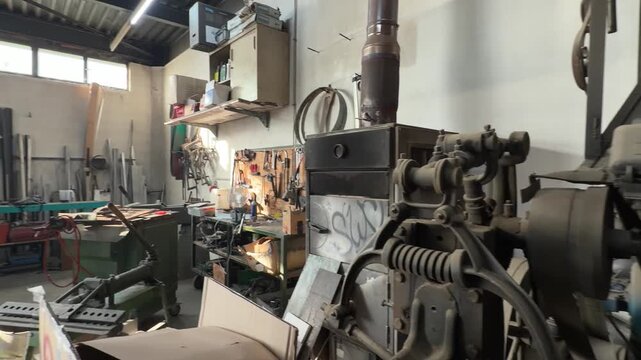 Old fashioned artisan metalworking workshop filled with various tools, machinery, and equipment for heavy industry and precision craftsmanship