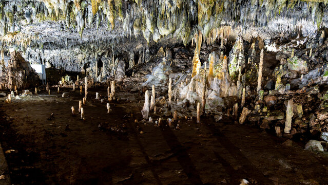 Stalactites and stalagmites in a dark limestone cave