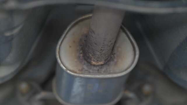 Close up shot of car exhaust pipe and metal muffler.