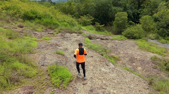 Drone view of man trail running through the mountains. The extreme outdoor sport represents endurance and personal challenge while pursuing fitness goals, achievement and an active healthy lifestyle.
