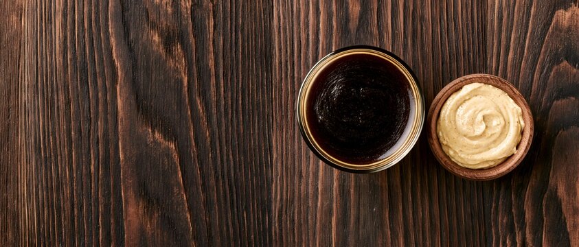 Top-down view of two sauce bowls on textured wood