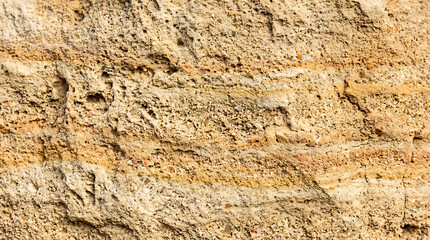 Naklejka premium Close-up texture of aged, cracked, and weathered beige wall surface with peeling paint and rough, uneven texture