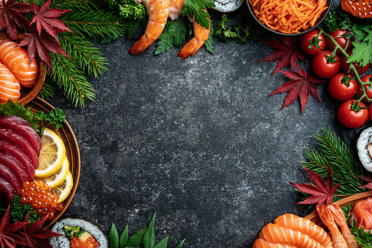 Fresh japanese sushi ingredients and seafood arranged as a frame on dark background