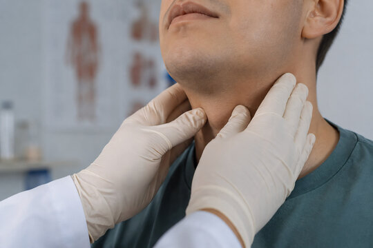 Close-up shot of a physician's gloved hands gently palpating the cervical lymph nodes on a patient's neck area during a medical physical exam