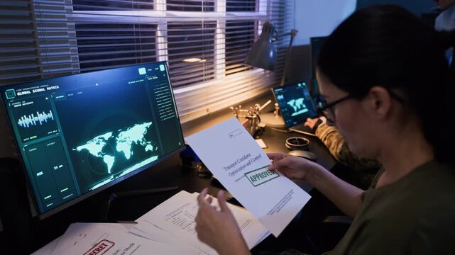 Young adult Caucasian female officer analyzing approved logistics documents in military command center. Video is suitable for national security and defense industry presentations
