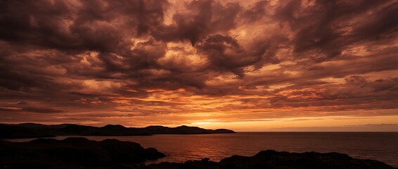 Fototapeta premium sunset over the river , Dramatic Fiery Sunset Sky Over Calm Ocean and Coastal Hills Landscape