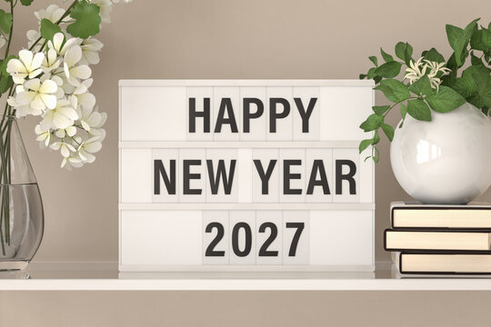 A lightbox displaying the words "Happy New Year 2027" on a shelf with books and plants.