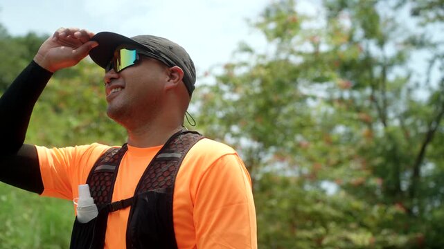 Portrait man trail running through a mountain forest. Extreme outdoor workout represents endurance, personal challenge and determination while pursuing fitness goals and a healthy active lifestyle.
