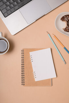 Coffee cup, notebook, pencil, and dessert on a desk at home during afternoon