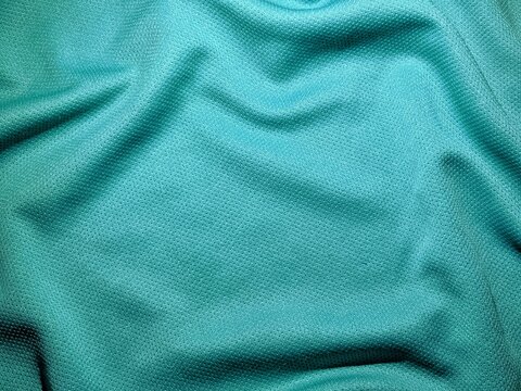 Crumpled cyan polyester fabric texture with mesh pattern background