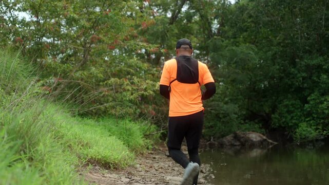 Man trail running through a mountain forest. Extreme outdoor workout represents endurance, personal challenge and determination while pursuing fitness goals and a healthy active lifestyle.
