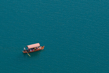 Traditional pletna boat sailing on turquoise alpine lake for European summer travel concept © Vadim Volodin