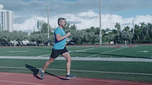 Morning run. Man running at racetrack outdoor. Runner sprinter with incredible speed. Sport runner completing a marathon. Sport training. Man sportsman running for exercise. Sprinting athlete