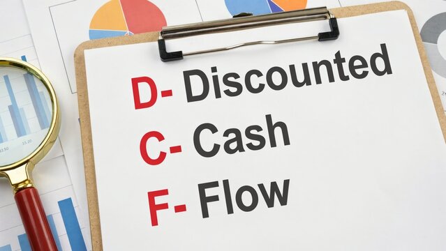 Clipboard with discounted cash flow text and magnifying glass on charts