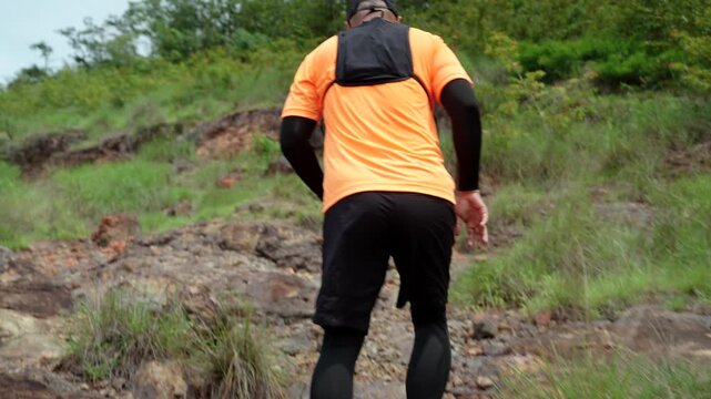 Man trail running through mountains during an extreme outdoor workout. Scene represents endurance, personal challenge and determination while pursuing fitness goals, achievement an active lifestyle.
