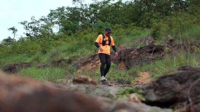 Man trail running through mountains during an extreme outdoor workout. Scene represents endurance, personal challenge and determination while pursuing fitness goals, achievement an active lifestyle.
